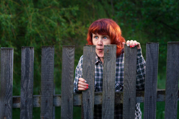 istock Woman peeking from behind a fence 646741880