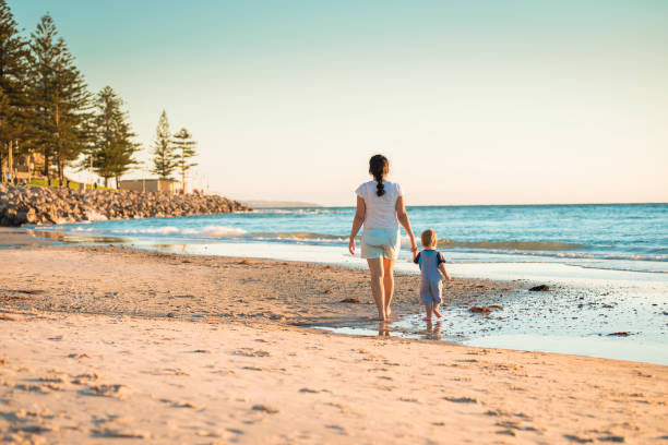 istock Mother and son walking on beach 646744448