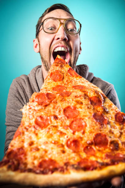 człowiek zjada oversized pizza slice - eating food biting pizza zdjęcia i obrazy z banku zdjęć