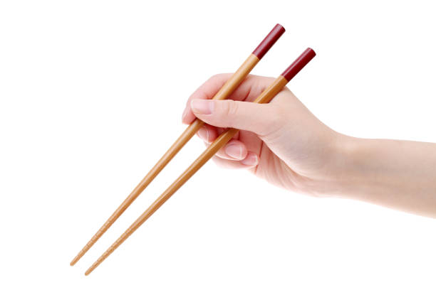 Hand holding wooden chopsticks stock photo