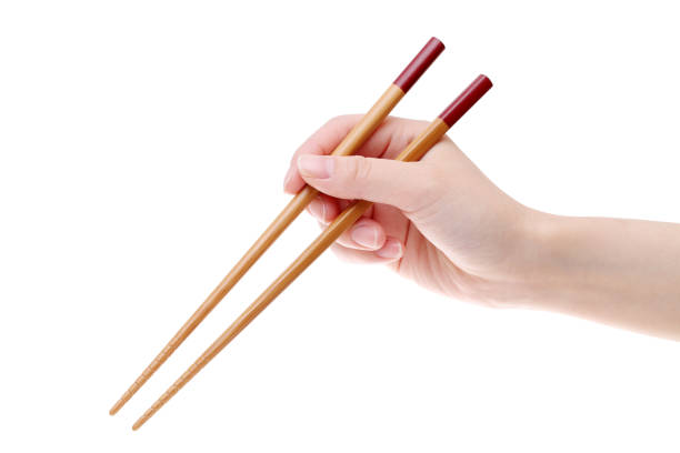 hand holding wooden chopsticks - hashis imagens e fotografias de stock