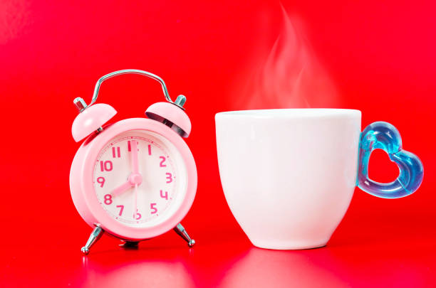 istock Vintage pink alarm clock with hot coffee. 646754986