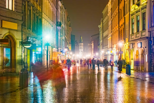 Night street in the Krakow, Poland. Colorful night illumination reflecting in the wet stone pavement of the old town. Beautiful background photo.