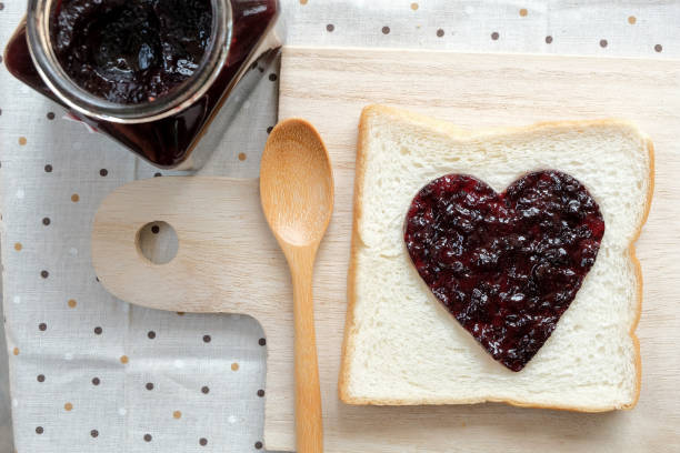 istock Toast with jam in shape of hearts on tablecloth background.  Top view 646764138
