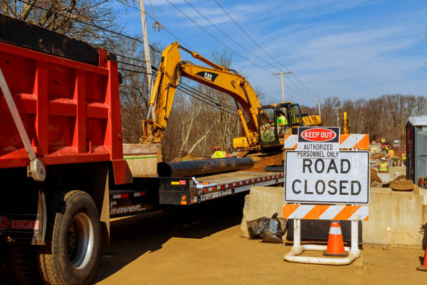 flag man points to a road closed sign on a highway flag man points to a road closed sign on a highway repair work on the road uci road world championships stock pictures, royalty-free photos & images