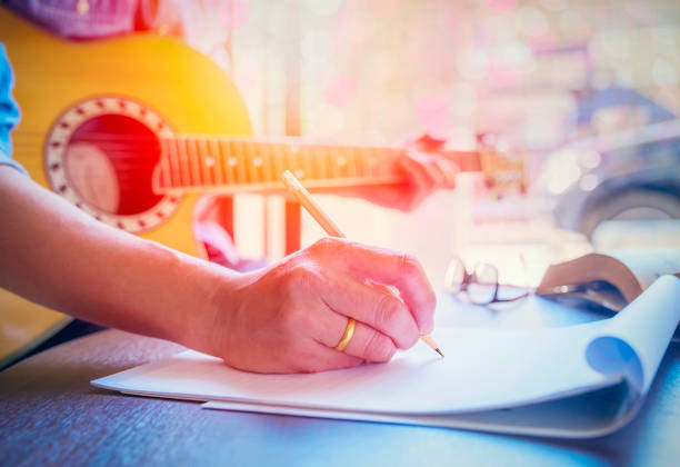 uomo che suona la chitarra acustica - lyricist foto e immagini stock