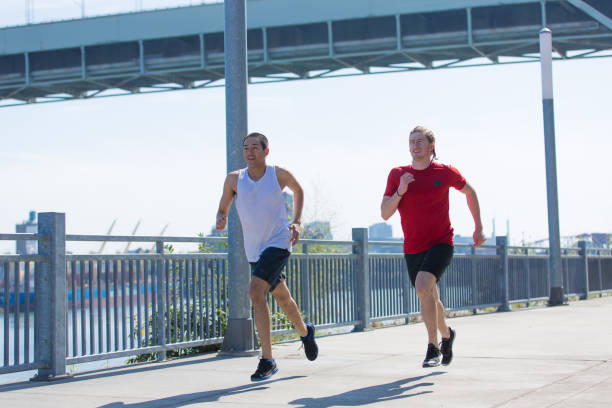 istock Two friends jogging outside along a river 646770674