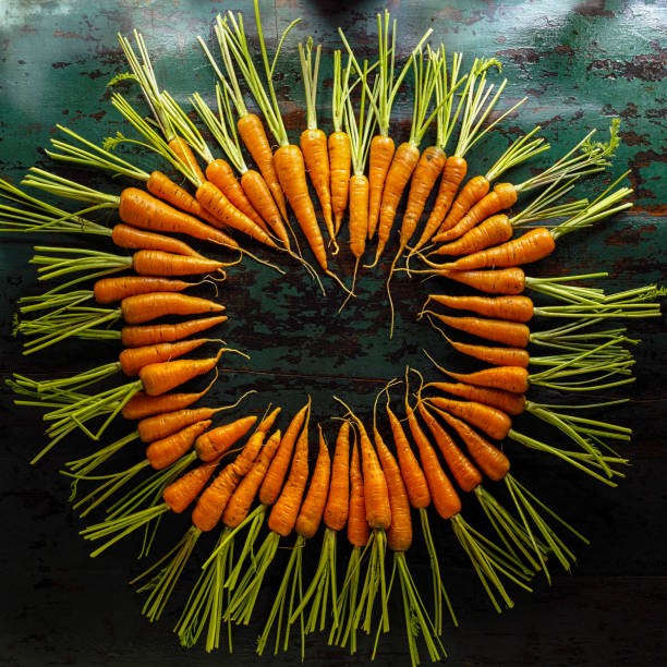 Market fresh organic carrots on an old weathered wooden background.