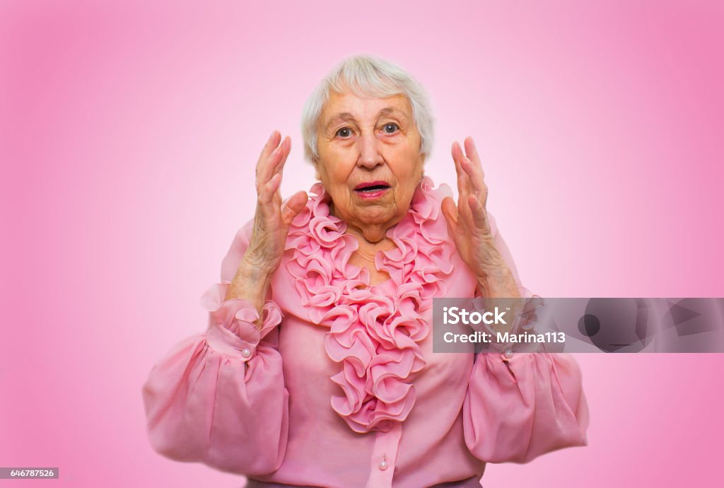 Elderly surprised woman Elderly surprised woman on rose studio background Only Senior Women Stock Photo