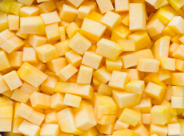 istock Orange vegetable pumpkin is cut by small square slices simple background 646794418