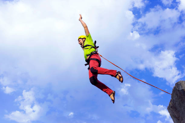 istock Jump rope from a high rock in the mountains. 646801648