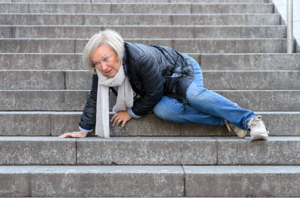 haute femme chute dans les escaliers de pierre à l’extérieur - falling senior adult people one person photos et images de collection