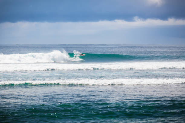 istock Tropical surfing on blue wave in Bali. Clouds 646811728