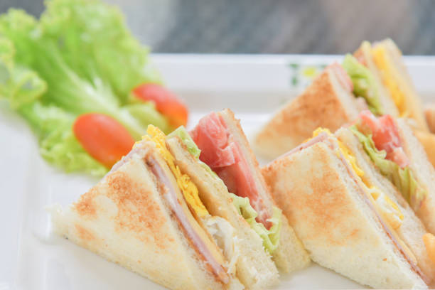Sanwiches breakfast with salad and tomato on the white plate