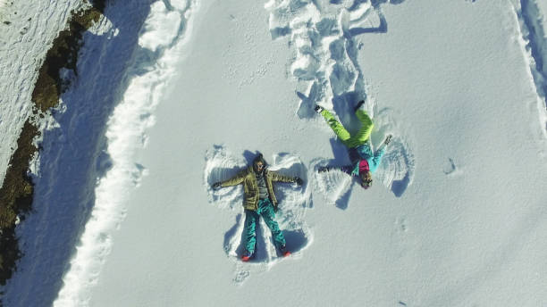 istock Couple making angel silhouette in snow 646820428