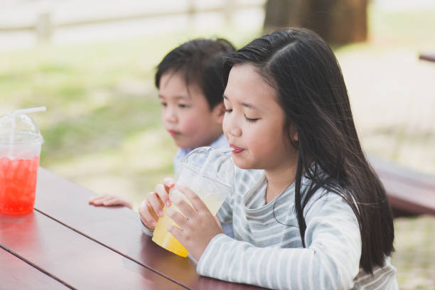 istock Cute asian children drinking fresh  juice 646820474