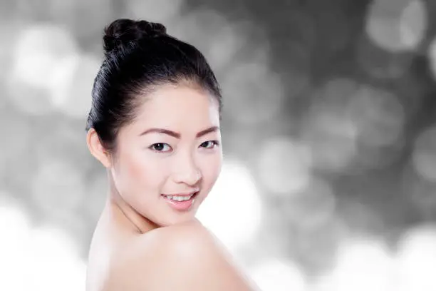 Portrait of young model with healthy skin face, looking at the camera with blur background