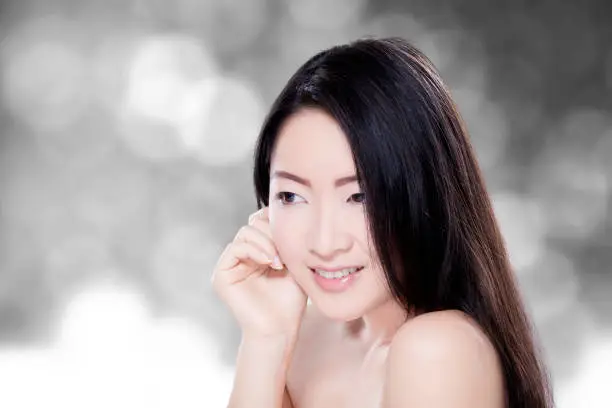 Portrait of young model with beautiful skin, smiling and posing with blur background