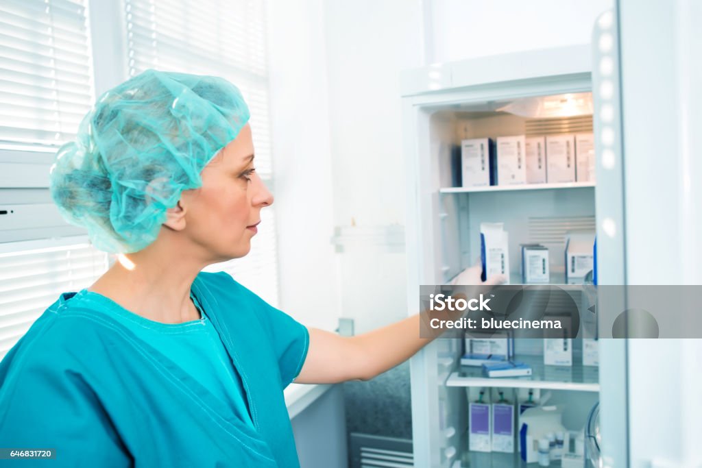 Researcher with Samples Scientist holding experiment sample in laboratory medical freezer Refrigerator Stock Photo