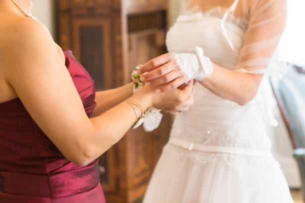 istock Bridesmaid is helping the bride to buttoning wedding dress 646833210