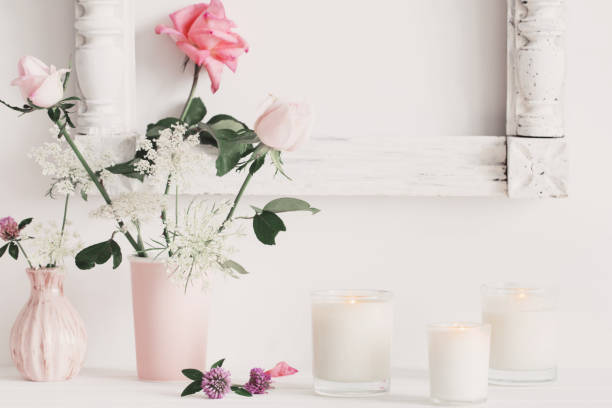 flowers in a vase and candles on white background