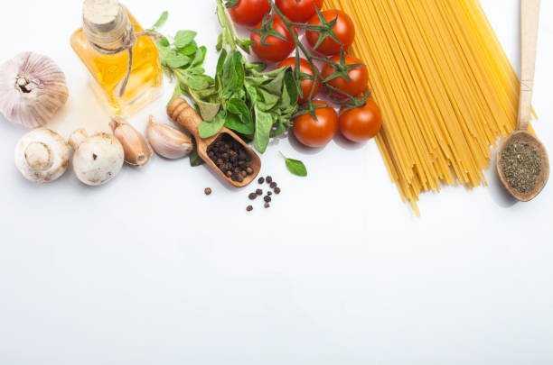 Food frame. Pasta ingredients. Spaghetti ,cherry-tomatoes, garlic, onion, mushrooms, carrots, basil, olive and spices on white backdrop, copy space, top view
