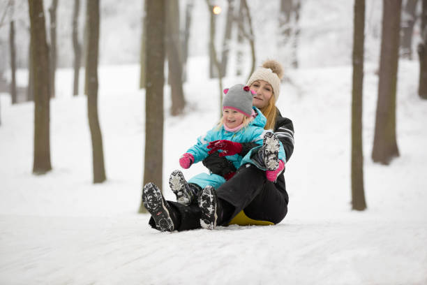 istock Mother and daughter sleddging 646840910