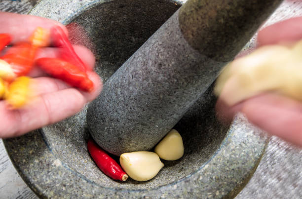 istock Pepper and garlic pounded in a stone mortar 646841462