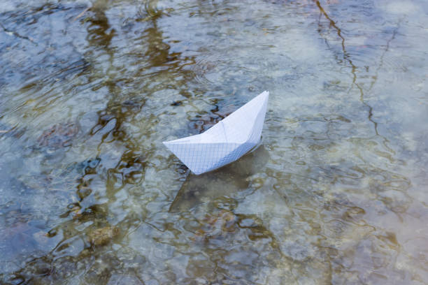 istock Paper boat in a puddle of melt water 646843802