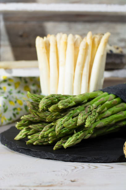 istock Spring season - fresh white and green asparagus on black stone plate 646845180