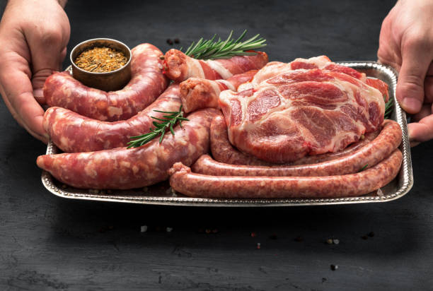 Male hands holding a iron tray with a meat for grilling