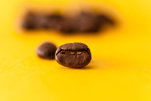 istock Roasted arabica coffee beans scattered on a yellow background 646852036