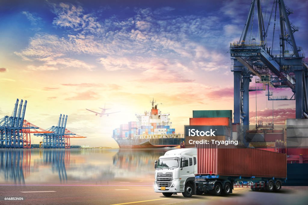 Logistics import export background and transport industry of Container truck and Cargo ship with working crane bridge in shipyard at sunset sky Freight Transportation Stock Photo
