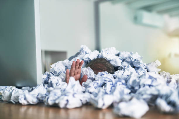 Drowning in a sea of admin Shot of an unidentifiable businessman drowning under a pile of paperwork buried stock pictures, royalty-free photos & images