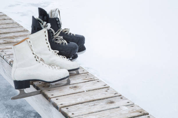 istock Old white and black skates on the wooden bench. 646860402