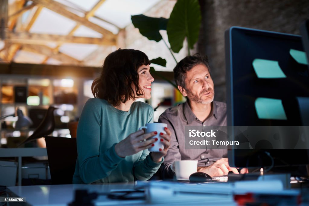 Working late in a small office in Barcelona Small business, working at the office. Technology Stock Photo