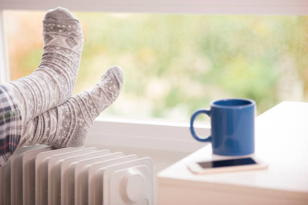 Woman feet resting on the warm radiator.