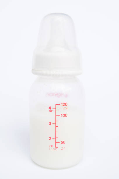 Baby bottle with milk and a measuring scale