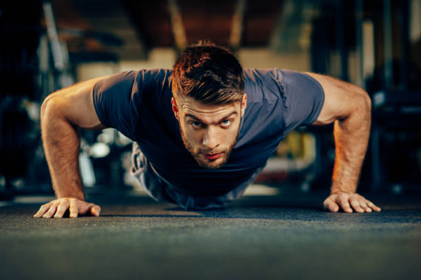 istock Handsome man doing pushups in the gym 646872588