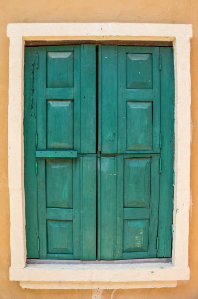 istock Green wood window on the orange wall 646873614