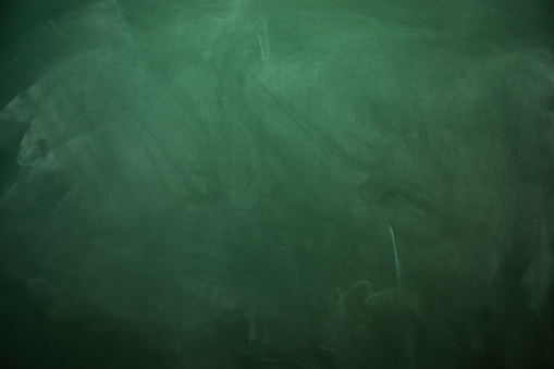 Blank green chalkboard with traces of erased chalk
