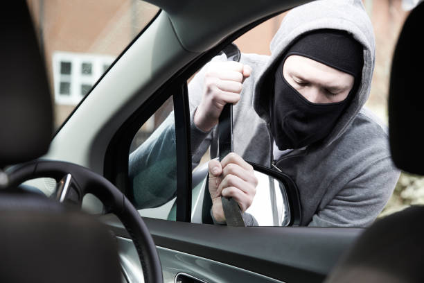 maskierte mann in auto mit brecheisen brechen  - car stealing thief car thief stock-fotos und bilder
