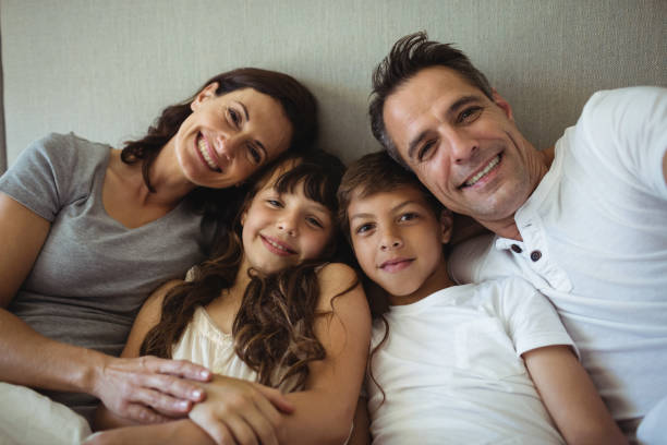 istock Parents and kids sitting on the bed 646887488