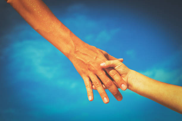 istock helping hand of mother and child on sky 646892164
