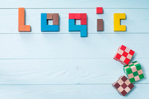 Logic background. The concept of logical thinking. The word of logic of multi colored wooden blocks on a wooden background