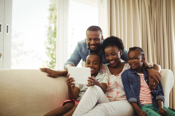 istock Parents and son using digital tablet on sofa in living room 646911190