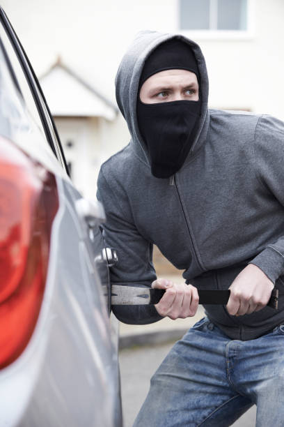 istock Masked Man Breaking Into Car With Crowbar 646911624