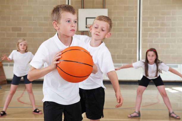 istock Elementary School Pupils Playing Basketball In Gym 646911732