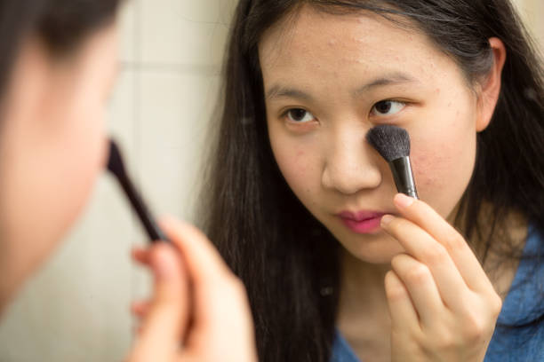 istock Asian teenager putting on makeup 646916344
