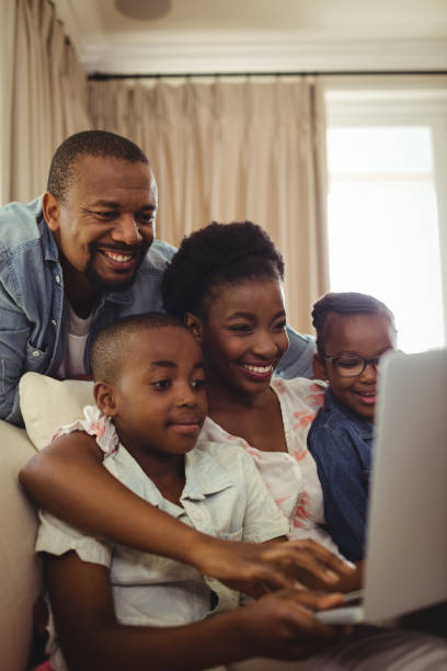 istock Parents and kids using laptop in living room 646916418